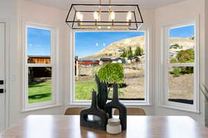 Dining area featuring a mountain view, a chandelier, and a healthy amount of sunlight