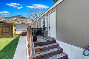 Entrance to property with a lawn and a deck with mountain view