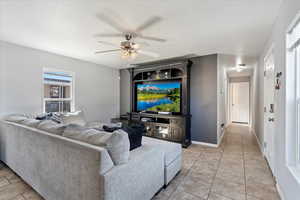 Living room with light tile patterned flooring and ceiling fan