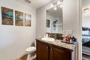 Bathroom featuring tile patterned flooring, ceiling fan, vanity, and toilet