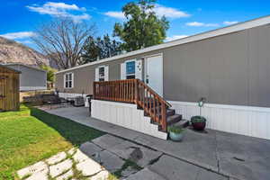 View of exterior entry featuring a yard and a patio