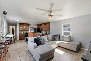 Living room featuring ceiling fan and light tile patterned floors