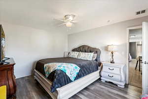 Bedroom with ceiling fan and dark hardwood / wood-style floors