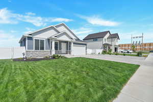 Craftsman-style house featuring a garage and a front lawn