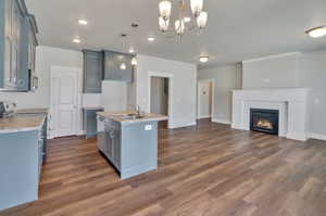 Kitchen with pendant lighting, dark wood-type flooring, sink, an island with sink, and stainless steel appliances