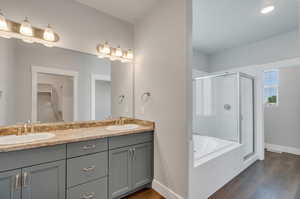 Bathroom featuring plus walk in shower, wood-type flooring, and vanity