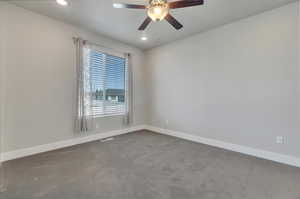 Carpeted spare room with ceiling fan