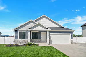 Craftsman-style house featuring a garage and a front yard