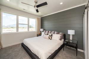 Carpeted bedroom featuring ceiling fan, a mountain view, and a barn door