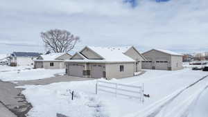 View of front of house with a detached garage and fence