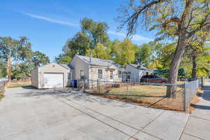 View of front of home with a garage and an outbuilding