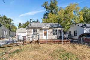 Bungalow-style house featuring a deck and a front yard