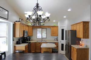 Kitchen featuring a chandelier, stainless steel appliances, sink, and plenty of natural light