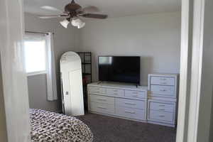 Carpeted bedroom with a textured ceiling and ceiling fan