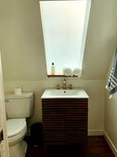 Bathroom featuring hardwood / wood-style flooring, vanity, and toilet