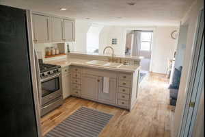 Kitchen featuring a textured ceiling, kitchen peninsula, sink, and stainless steel appliances