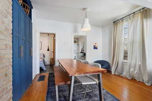 Dining room featuring dark wood-type flooring and brick wall