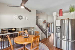 Dining room with dark hardwood / wood-style flooring, ceiling fan, and high vaulted ceiling