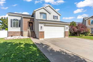 View of front of home featuring a front lawn and a garage