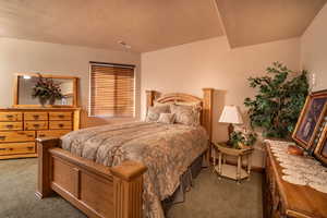 Carpeted bedroom featuring a textured ceiling