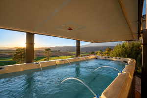 View of swimming pool featuring a mountain view and a hot tub