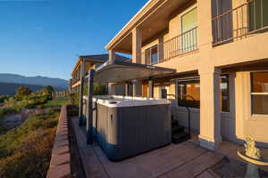 Exterior space with a balcony, a hot tub, and a mountain view