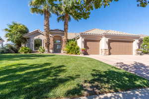 Mediterranean / spanish-style house with a garage and a front lawn