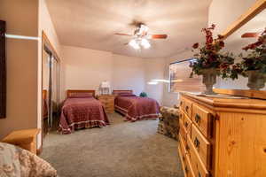 Bedroom featuring ceiling fan and carpet