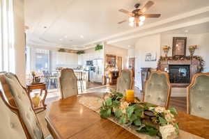 Dining area with ceiling fan, a tray ceiling, and light hardwood / wood-style floors