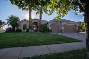 Mediterranean / spanish-style home featuring a garage and a front lawn