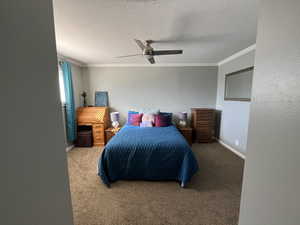 Bedroom with a textured ceiling, ceiling fan, carpet flooring, and crown molding