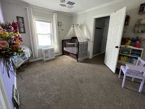 Carpeted bedroom featuring ornamental molding