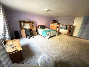 Bedroom featuring a textured ceiling and carpet floors