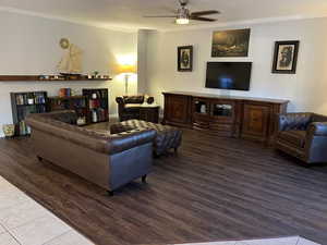 Living room with ceiling fan, hardwood / wood-style flooring, and crown molding