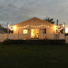 Back of house featuring a deck and a yard