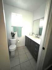 Bathroom featuring tile patterned flooring, vanity, toilet, and plenty of natural light