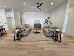 Living room with ceiling fan and light wood-type flooring