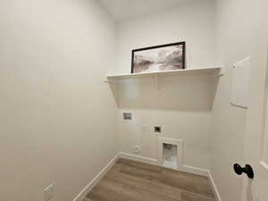 Laundry room featuring hookup for a gas dryer, hardwood / wood-style flooring, washer hookup, and electric dryer hookup