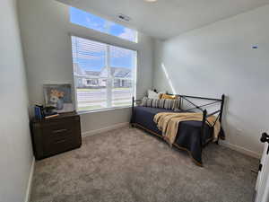 Bedroom featuring light carpet and a textured ceiling