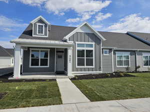 View of front of home featuring covered porch and a front lawn