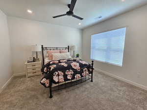 Carpeted bedroom featuring ceiling fan