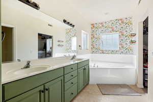 Bathroom featuring a tub to relax in and vanity