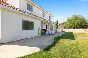 Rear view of property with a patio area and a yard