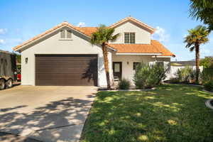 Mediterranean / spanish home with a front lawn and a garage