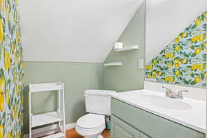 1/2 Bathroom featuring wood-type flooring, vanity, and toilet