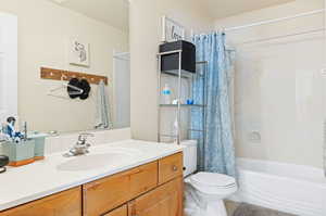 Full bathroom featuring vanity, toilet, and shower / bath combination with curtain