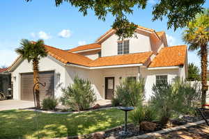 Mediterranean / spanish-style home featuring a front yard and a garage