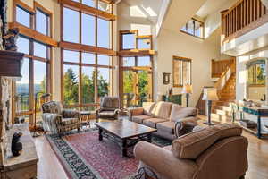 Living room featuring a healthy amount of sunlight, a high ceiling, and light hardwood / wood-style flooring