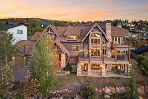 Back house at dusk featuring a patio and a balcony