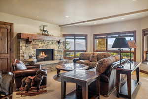 Living room with light carpet and a stone fireplace